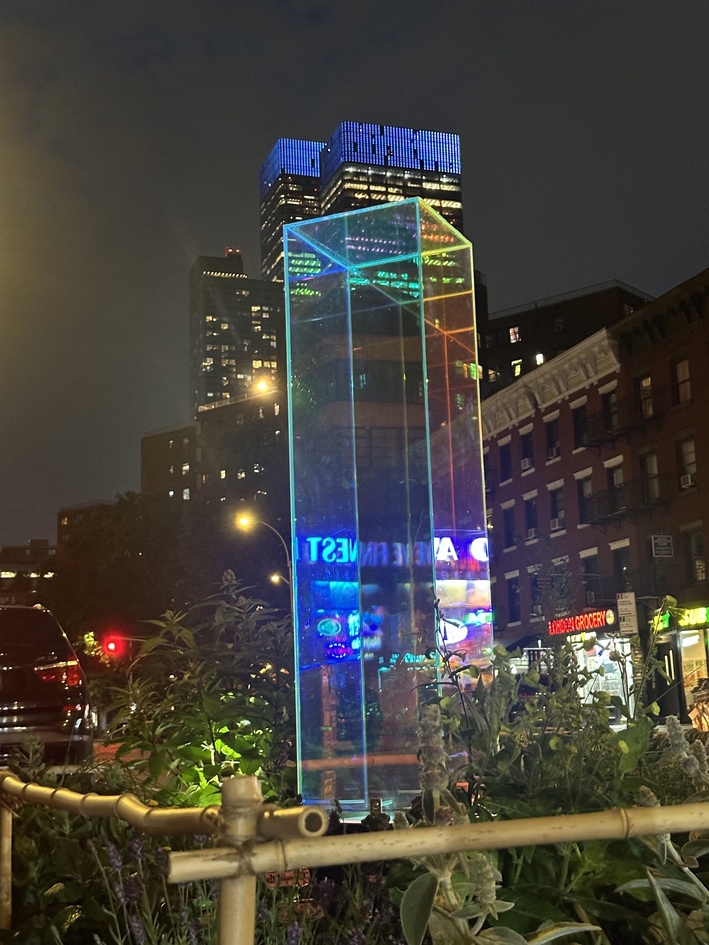 The gazing ball installation glowing at night among the plantings at Itty Island in West Chelsea