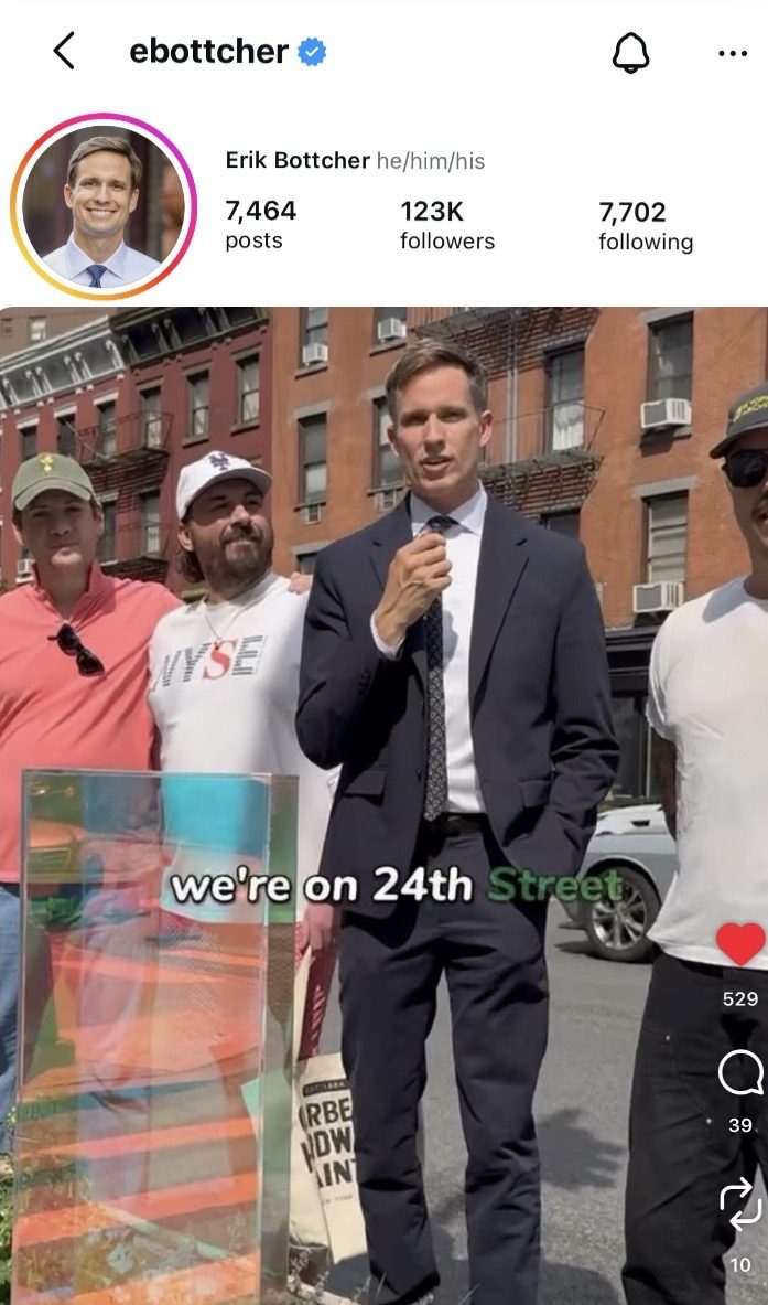 State Senator Erik Bottcher filming an Instagram reel on West 24th Street beside the Itty Island gazing ball, with neighbors standing alongside him